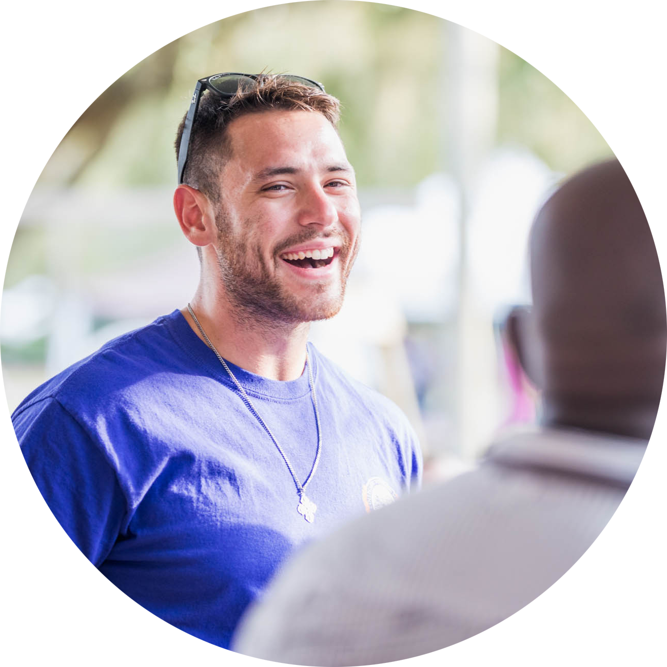 Veteran in a blue shirt smiles at another student.